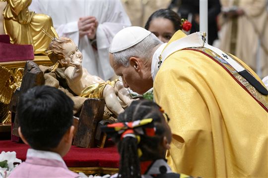 24 de dezembro de 2025 - O Papa Leão beija a estátua do Menino Jesus no início da missa da vigília de Natal (© Vatican Media/Catholic Press Photo)